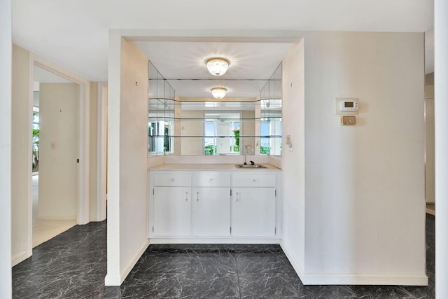 bar with white cabinetry and sink