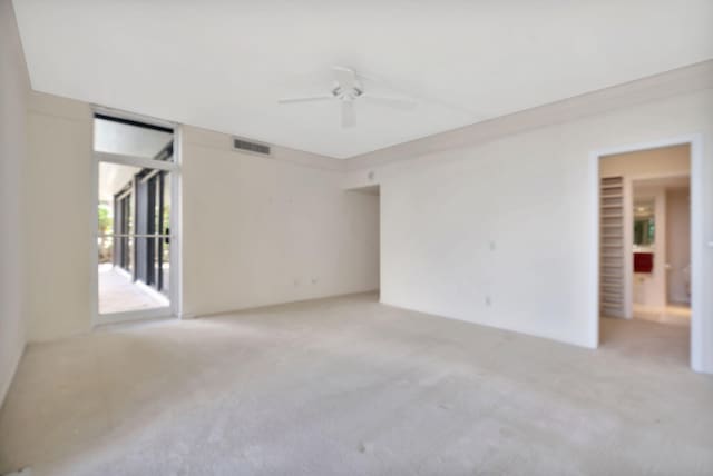 carpeted spare room with ceiling fan