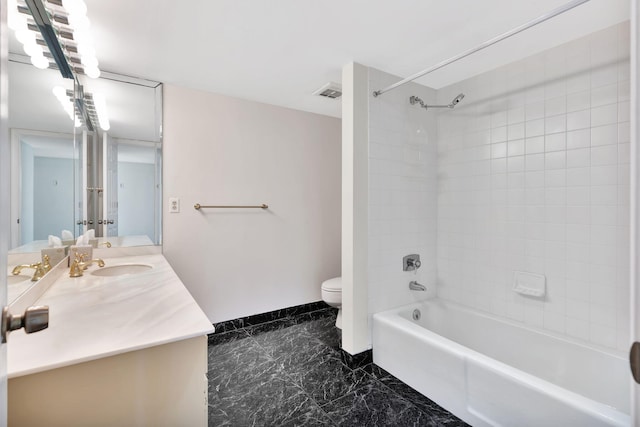 full bathroom featuring vanity, tiled shower / bath combo, and toilet