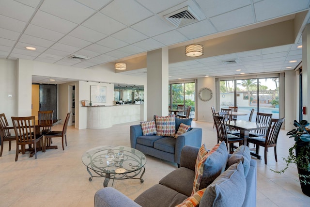 tiled living room with a paneled ceiling and a healthy amount of sunlight