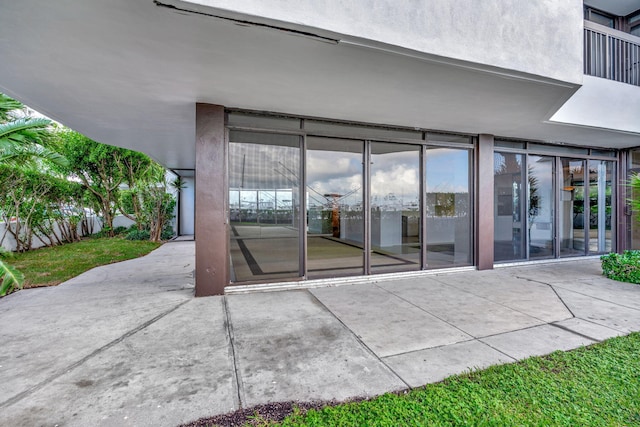 view of exterior entry with a patio