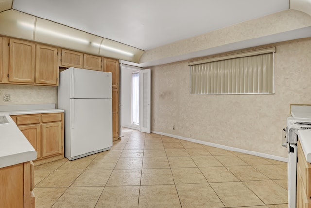 kitchen with light tile patterned flooring, light brown cabinets, and white appliances