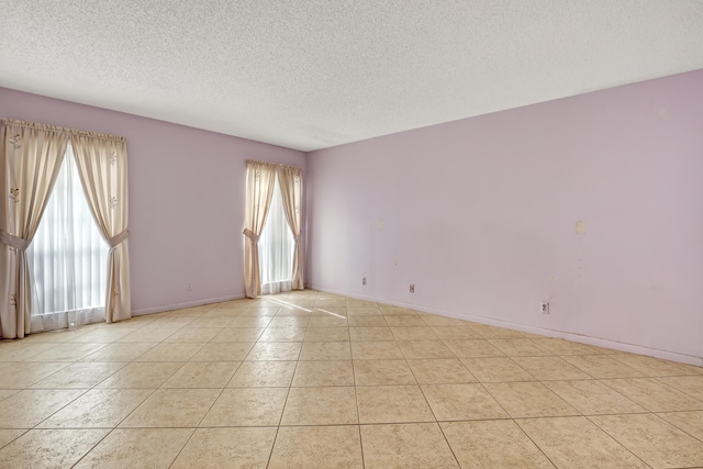 tiled spare room featuring a textured ceiling