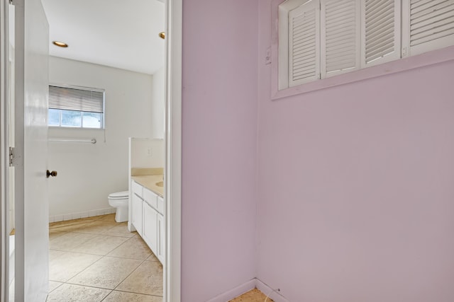 bathroom with toilet, tile patterned floors, and vanity