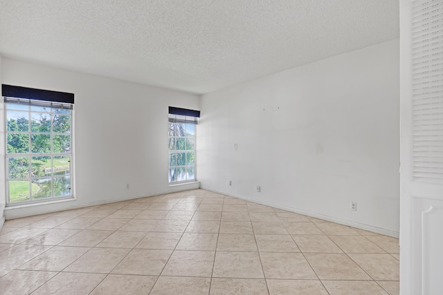 tiled spare room featuring a textured ceiling