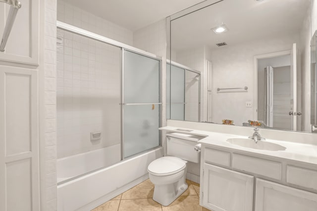 full bathroom featuring tile patterned flooring, vanity, toilet, and shower / bath combination with glass door