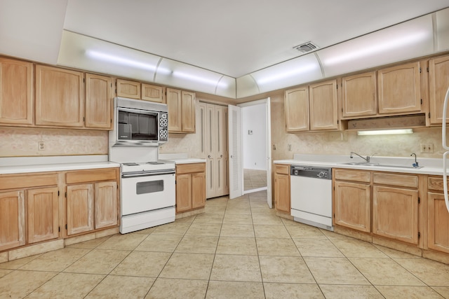 kitchen featuring light brown cabinets, white appliances, and light tile patterned floors