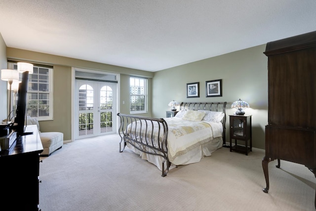 bedroom with access to outside, light colored carpet, a textured ceiling, and baseboards