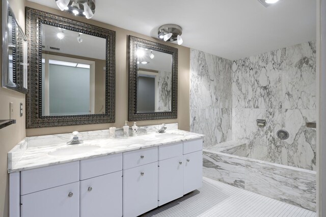 bathroom with double vanity, walk in shower, and a sink