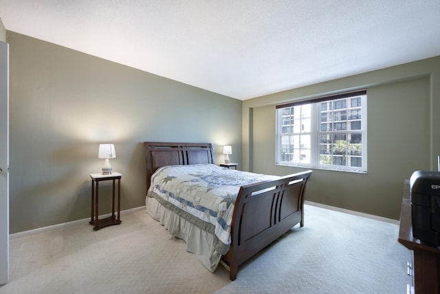 bedroom with light carpet and baseboards