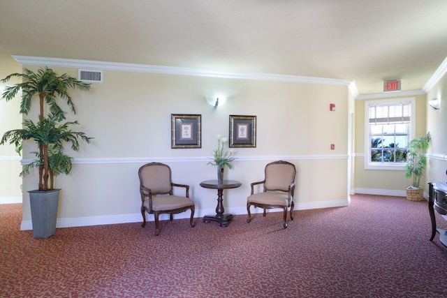 sitting room with carpet floors, baseboards, visible vents, and crown molding