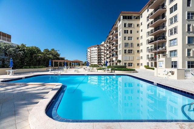 community pool with a patio and a pergola