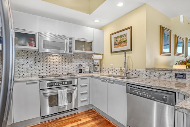 kitchen with white cabinets, backsplash, appliances with stainless steel finishes, and a sink