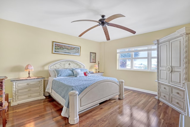 bedroom featuring a ceiling fan, dark wood-style floors, and baseboards