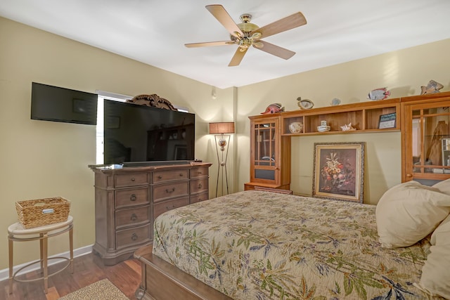 bedroom with a ceiling fan, baseboards, and wood finished floors