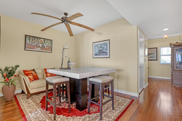 dining room featuring ceiling fan, baseboards, and hardwood / wood-style floors