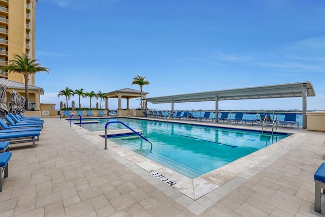 community pool with a gazebo and a patio