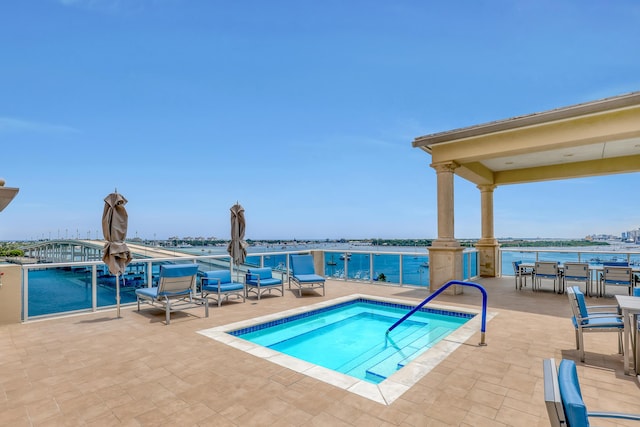 view of swimming pool with a patio and a water view