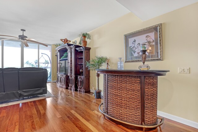 interior space with baseboards, wood finished floors, and a ceiling fan