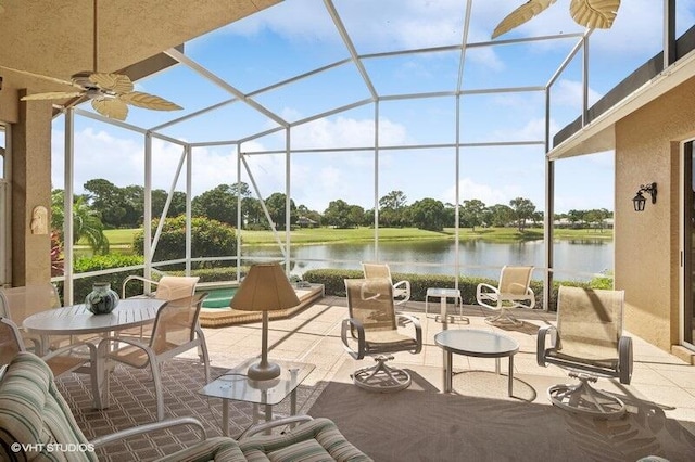 view of patio / terrace with a lanai, a water view, and ceiling fan