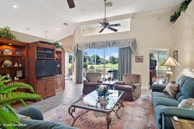 living room with ceiling fan, light tile patterned flooring, ornamental molding, and a healthy amount of sunlight