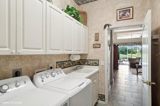 laundry area featuring washer and dryer, light tile patterned flooring, sink, and cabinets