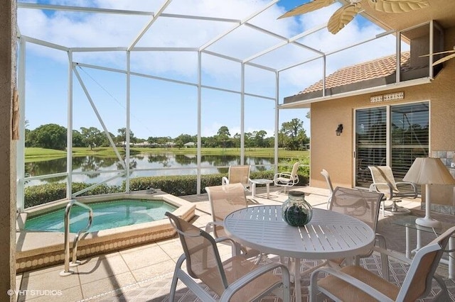 sunroom featuring ceiling fan and a water view