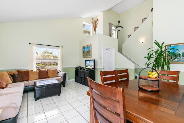 dining space with light tile patterned flooring and high vaulted ceiling