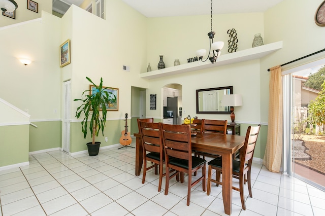 tiled dining space with a notable chandelier and high vaulted ceiling