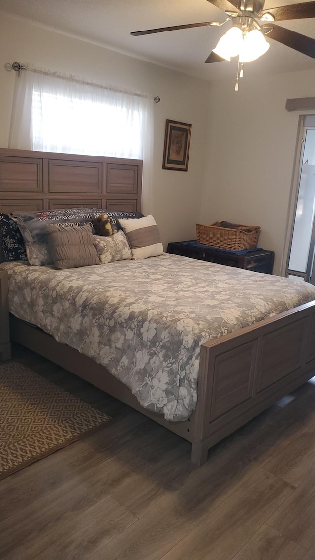 bedroom with dark hardwood / wood-style floors and ceiling fan