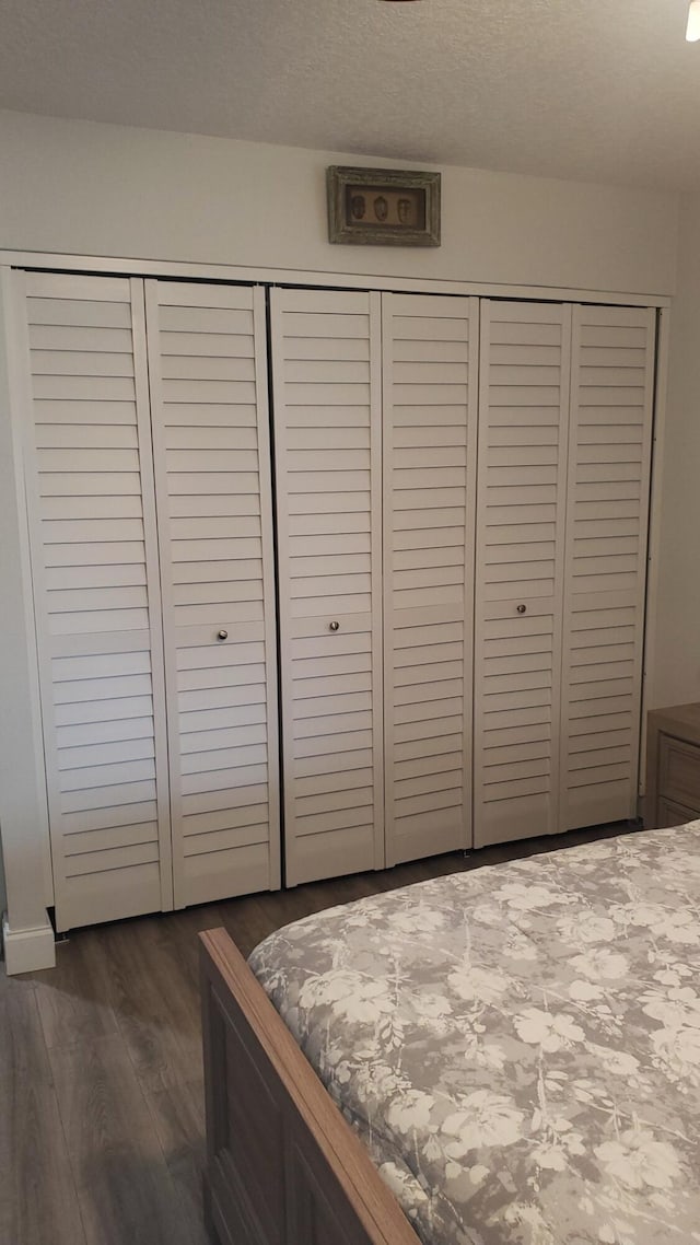 unfurnished bedroom featuring dark hardwood / wood-style flooring and a textured ceiling