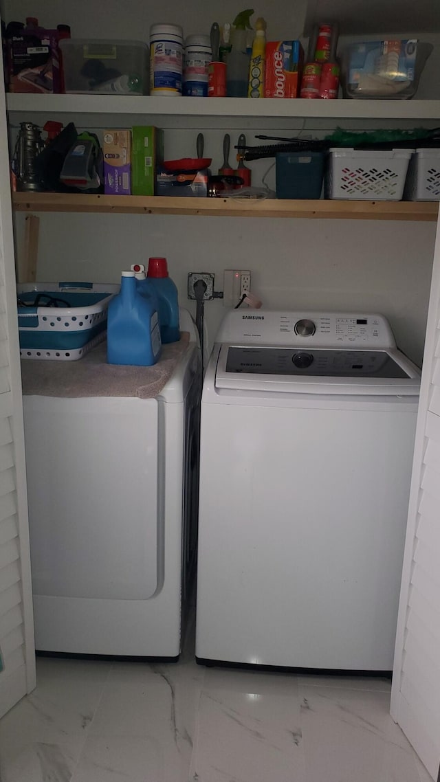 laundry room featuring light tile patterned floors and separate washer and dryer