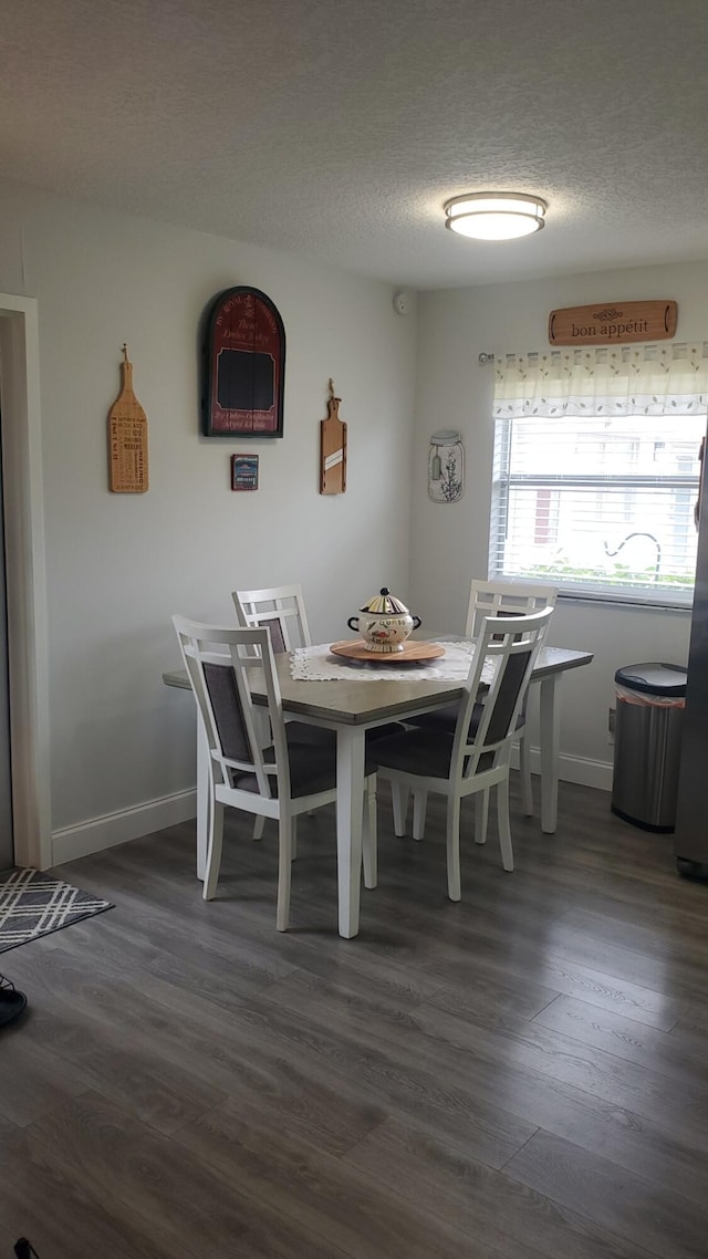 unfurnished dining area featuring wood-type flooring and a textured ceiling