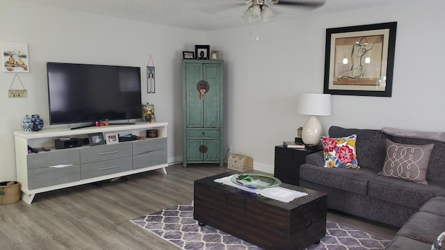 living room featuring a textured ceiling, dark hardwood / wood-style floors, and ceiling fan