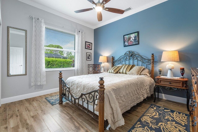 bedroom featuring ceiling fan, ornamental molding, and wood-type flooring