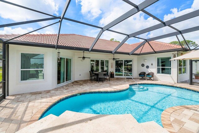 view of pool featuring a patio area, ceiling fan, and a lanai