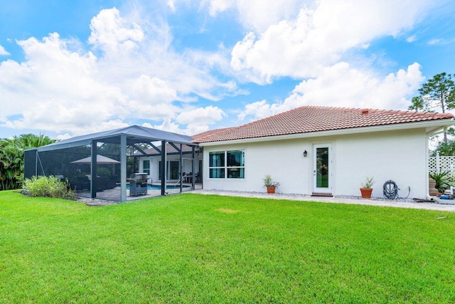 rear view of property featuring a yard, a patio area, glass enclosure, and a pool