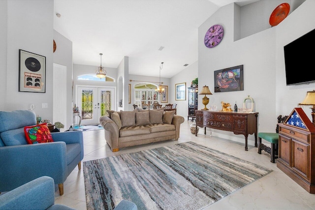 living room with high vaulted ceiling, a chandelier, and french doors