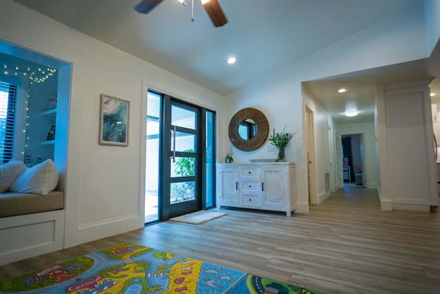 entrance foyer featuring lofted ceiling, ceiling fan, and light wood-type flooring