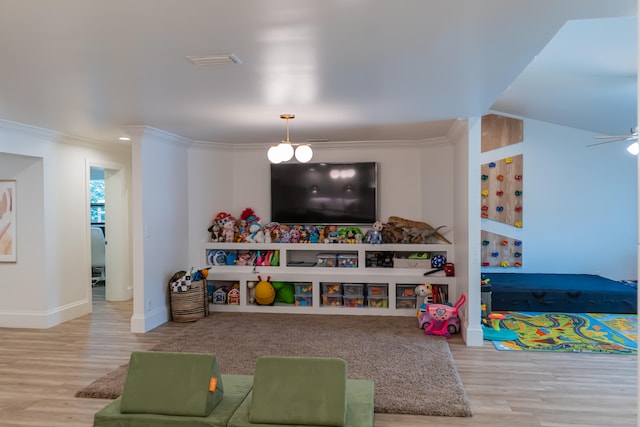 game room with crown molding, wood-type flooring, and ceiling fan