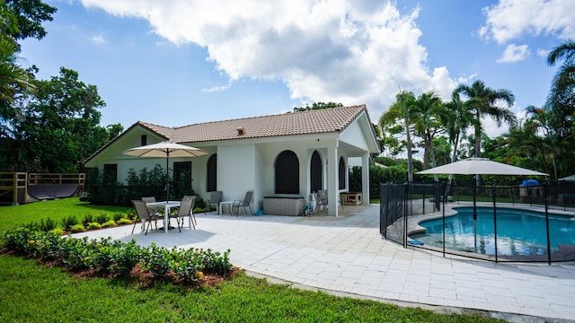 rear view of house with a patio and a fenced in pool