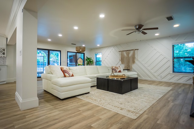 living room featuring ceiling fan, wood-type flooring, and a wealth of natural light