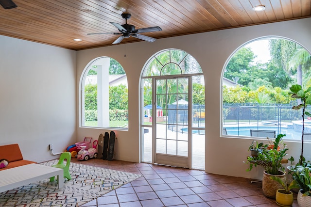 entryway with ornamental molding, light tile patterned floors, wooden ceiling, and ceiling fan