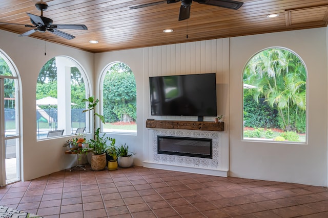 interior space with ceiling fan, a healthy amount of sunlight, and wooden ceiling