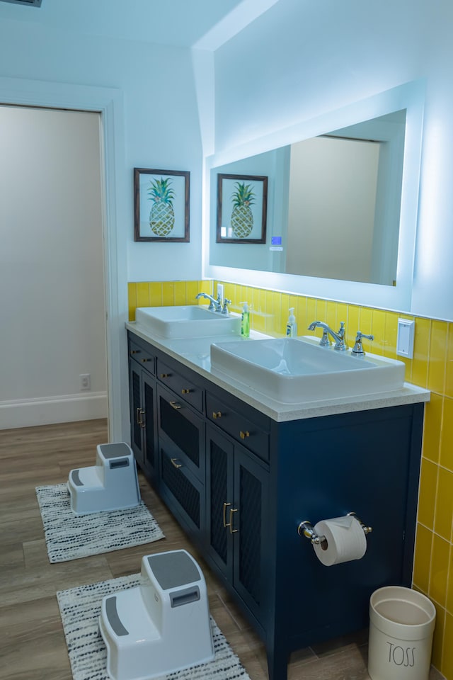 bathroom with vanity, hardwood / wood-style floors, tile walls, and backsplash