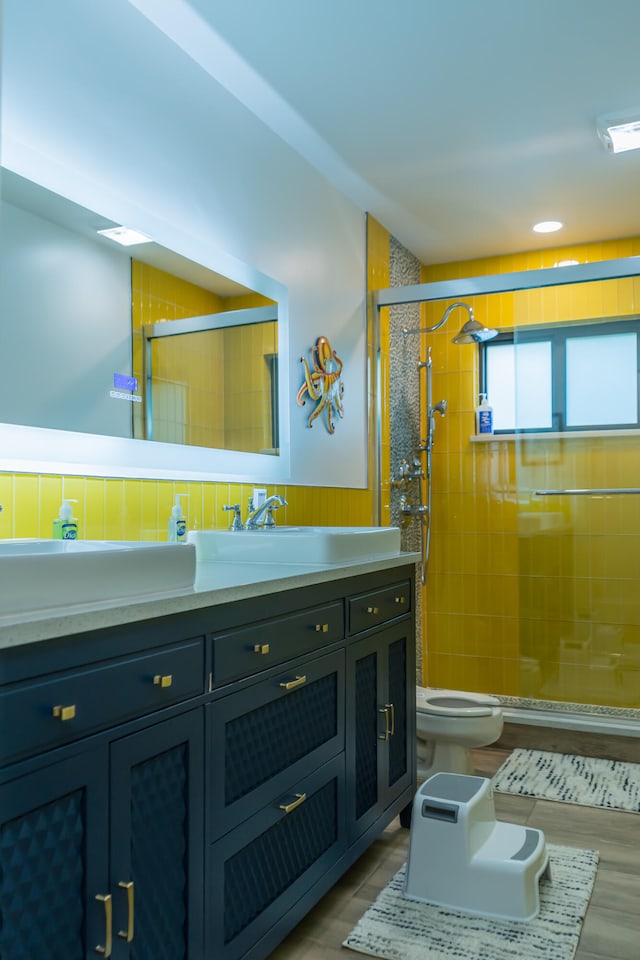 bathroom with a tile shower, vanity, and toilet