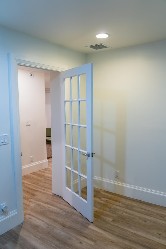 hallway featuring hardwood / wood-style floors and french doors