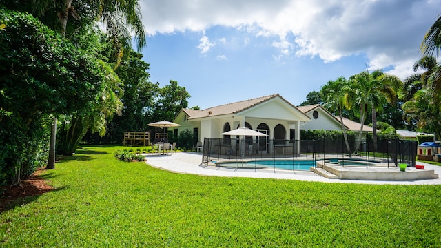 view of pool with a lawn and a patio