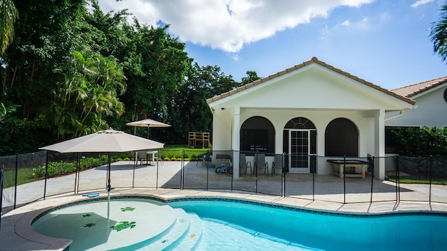 view of swimming pool with a patio and exterior bar