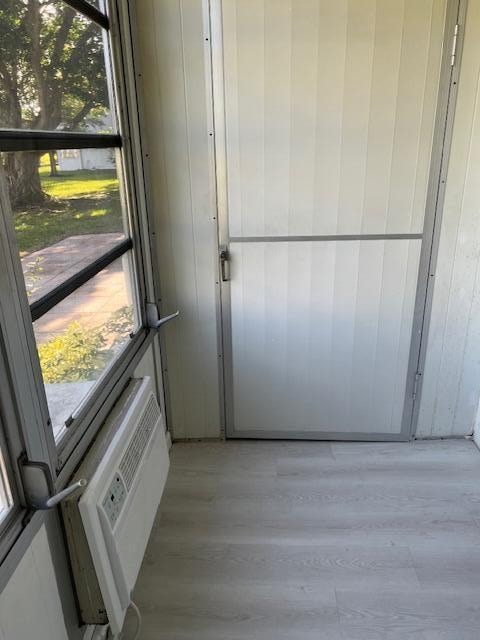 doorway to outside with light wood-type flooring and a wealth of natural light